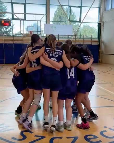 Die WU14 von CITY Basket Berlin feiert im Kreis auf dem Szczecin-Logo den 49:29-Auftaktsieg