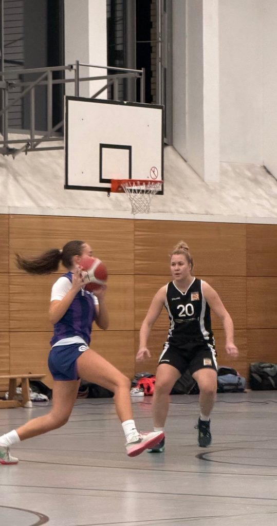 Spielerin von CITY Basket Berlin am Ball, Gegnerin in Schwarz verteidigt